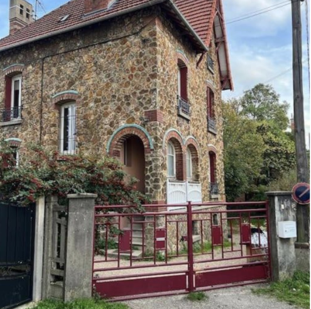 La maison SchoolBooster — bâtisse en pierre au portail rouge